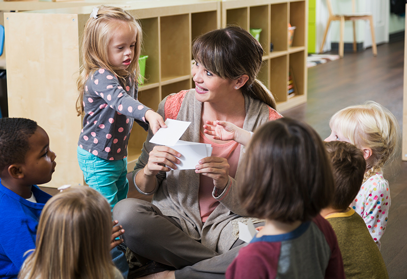 Vorschulische Hilfen - Gruppe von behinderten und nichtbehinderten Kindern mit einer Erzieherin